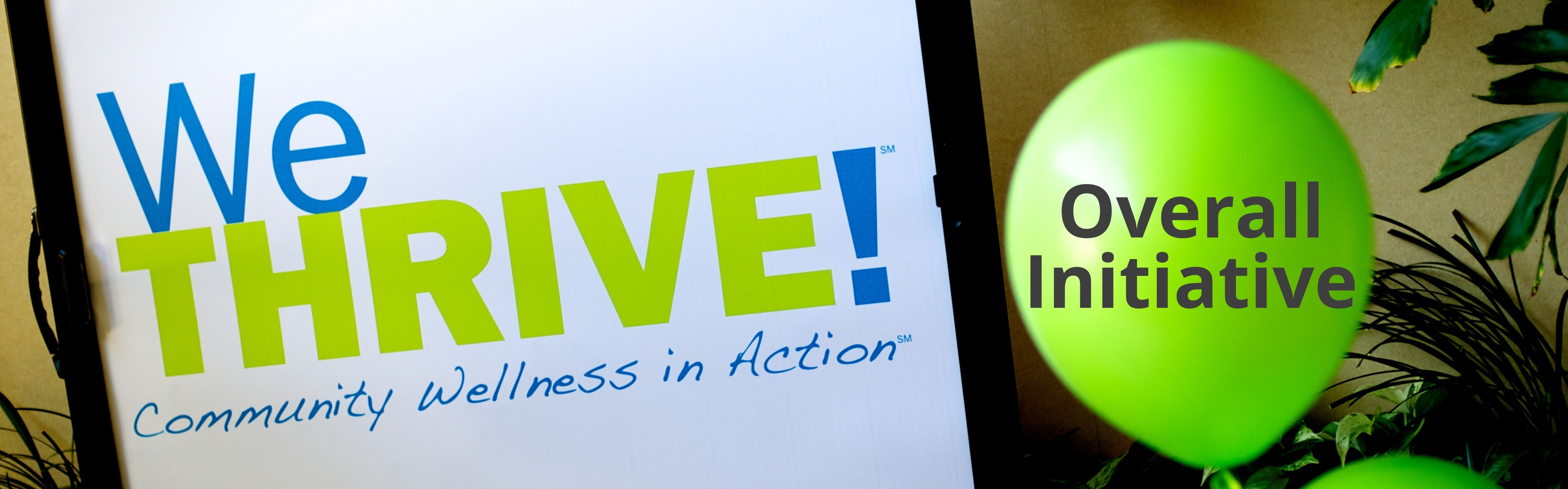 Sign that says WeThrive Community Wellness in Action with green balloon.